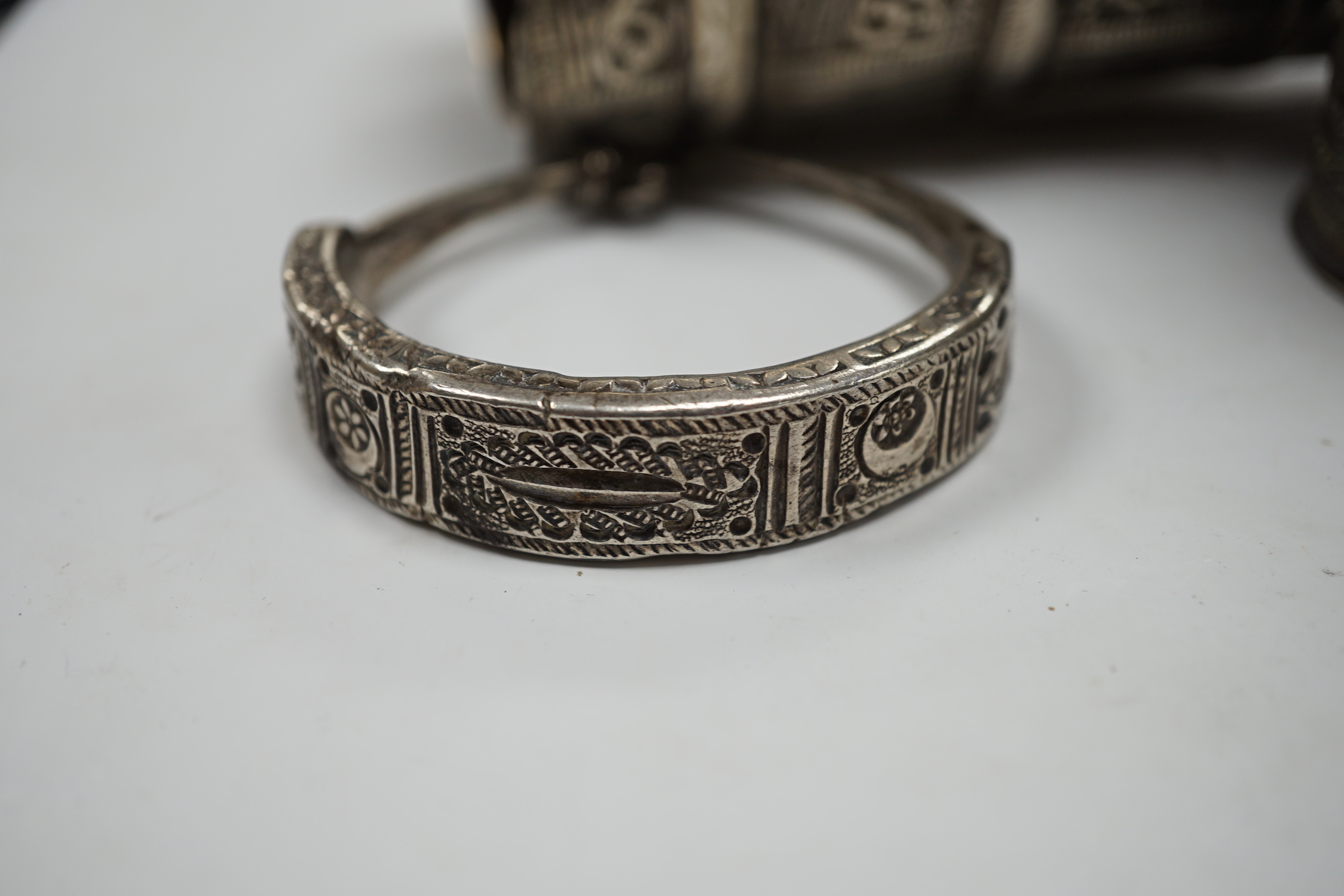 A collection of eight North African Berber white metal jewellery, etc, including bangles, cuffs and hair ornament.